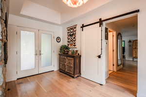 Entryway featuring a barn door, light wood-type flooring, and french doors