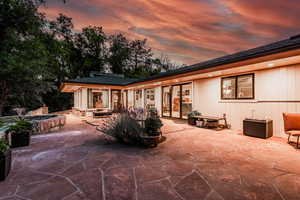 Back house at dusk with a patio