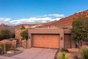 Pueblo revival-style home featuring a garage and a mountain view