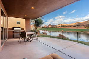 View of patio / terrace featuring a grill, a water and mountain view, and an outdoor kitchen