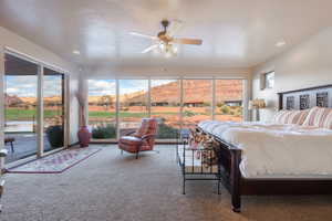 Carpeted bedroom with a mountain view, access to outside, and ceiling fan