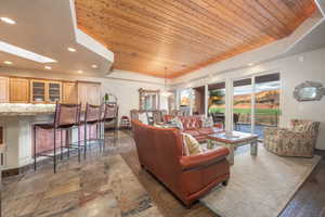 Living room with a skylight, wooden ceiling, and a tray ceiling