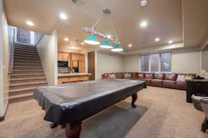 Recreation room featuring light colored carpet, a tray ceiling, pool table, and sink