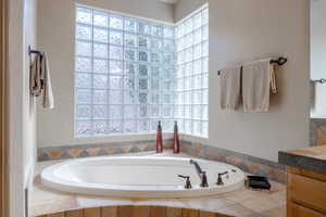 Bathroom featuring vanity and a relaxing tiled tub