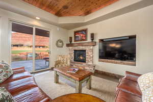 Living room with hardwood / wood-style flooring, a fireplace, a raised ceiling, and wooden ceiling