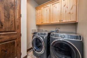 Laundry area with cabinets and washing machine and clothes dryer