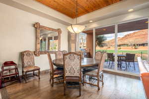 Dining room with a raised ceiling, hardwood / wood-style floors, and wood ceiling