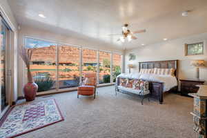 Bedroom with ceiling fan and light carpet