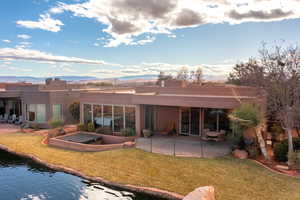 Rear view of house with a mountain view, a yard, and a patio area