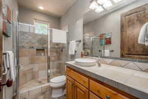 Bathroom with vanity, toilet, and walk in shower