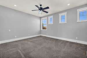 Spare room featuring carpet floors, a wealth of natural light, and ceiling fan