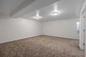 Spare room with a textured ceiling and carpet