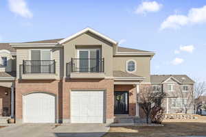 Townhome / multi-family property with a garage and a balcony