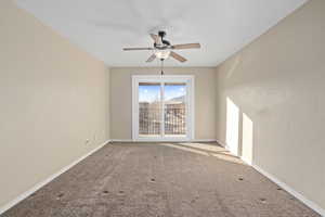 Carpeted empty room featuring ceiling fan