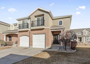 Multi unit property featuring a garage and a balcony