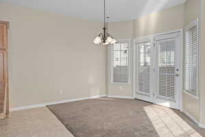 Tiled spare room featuring an inviting chandelier