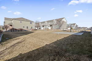 Rear view of house with a yard and basketball hoop