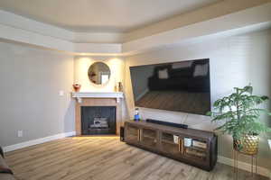 Living room with a tiled fireplace and hardwood / wood-style floors