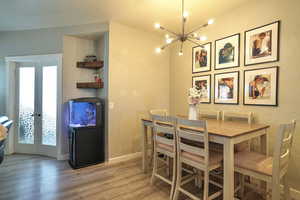 Dining area with french doors, light hardwood / wood-style floors, and a wealth of natural light