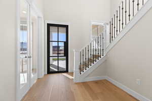 Entryway with light hardwood / wood-style flooring and a high ceiling