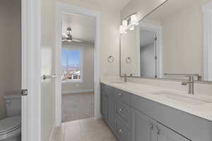 Bathroom with vanity, ceiling fan, tile patterned floors, and toilet