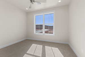 Carpeted empty room featuring ceiling fan