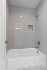 Bathroom featuring tile patterned flooring and tiled shower / bath combo