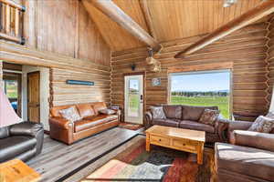 Living room with beamed ceiling, hardwood / wood-style floors, wood ceiling, and high vaulted ceiling