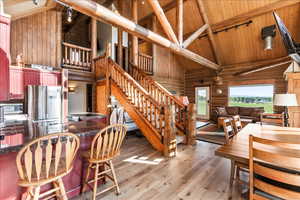 Interior space featuring hardwood / wood-style floors, beam ceiling, stainless steel appliances, high vaulted ceiling, and wooden ceiling