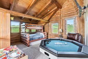 Bedroom featuring carpet floors, vaulted ceiling with beams, rustic walls, and wood ceiling