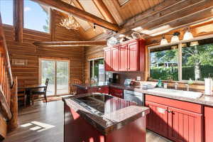 Kitchen featuring sink, dishwasher, beam ceiling, a center island, and light hardwood / wood-style floors