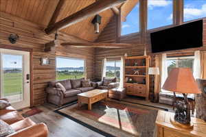 Living room featuring wood ceiling, wood-type flooring, high vaulted ceiling, and beamed ceiling