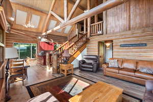 Living room featuring beam ceiling, hardwood / wood-style floors, wood ceiling, and high vaulted ceiling