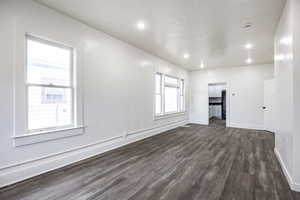 Empty room with dark hardwood / wood-style flooring