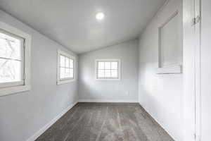 Carpeted empty room with lofted ceiling