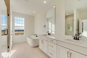 Primary bathroom with double vanity and stand alone tub