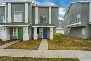 Townhome / multi-family property featuring a front lawn