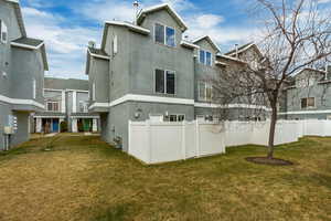 Rear view of property with a yard