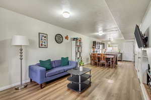 Living room with light hardwood / wood-style flooring and a textured ceiling