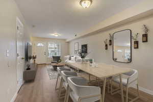 Dining room with light wood-style floors, visible vents, and baseboards