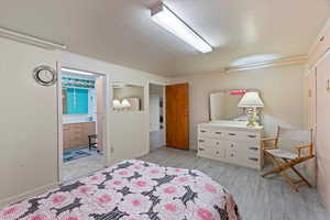 Bedroom featuring ensuite bath and light hardwood / wood-style flooring