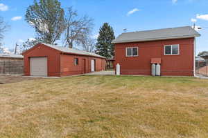 Exterior space with an outbuilding, a yard, and a garage