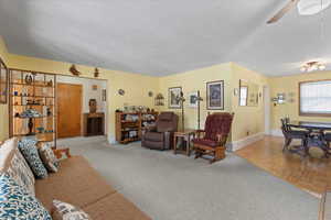 Carpeted living room featuring ceiling fan