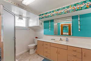 Bathroom with vanity, an enclosed shower, and toilet