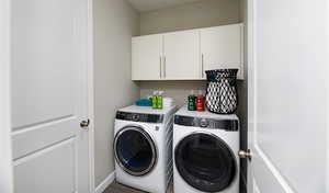 Laundry room featuring cabinets and washing machine and dryer