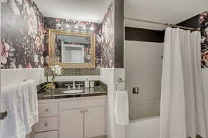 Bathroom featuring vanity and shower / tub combo with curtain