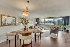 Living room featuring hardwood / wood-style floors, expansive windows, and a textured ceiling