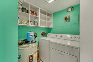 Washroom featuring independent washer and dryer and water heater