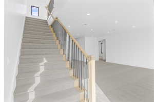 Staircase featuring carpet floors