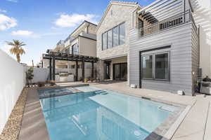 View of pool with exterior kitchen, a patio, a grill, and a pergola